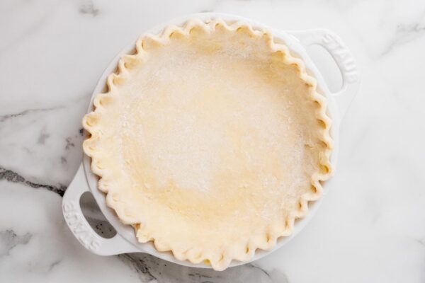 pie crust in a pie pan with crimped edges.