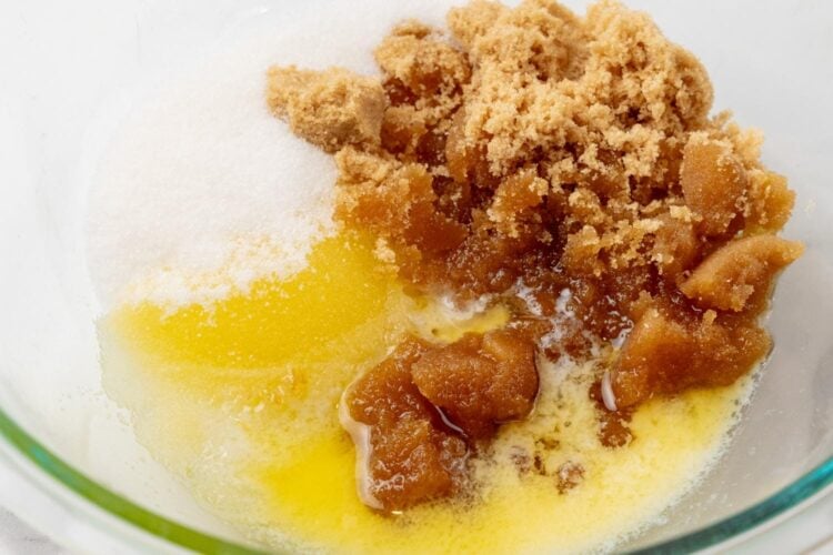brown sugar, white sugar, and melted butter in a glass bowl.