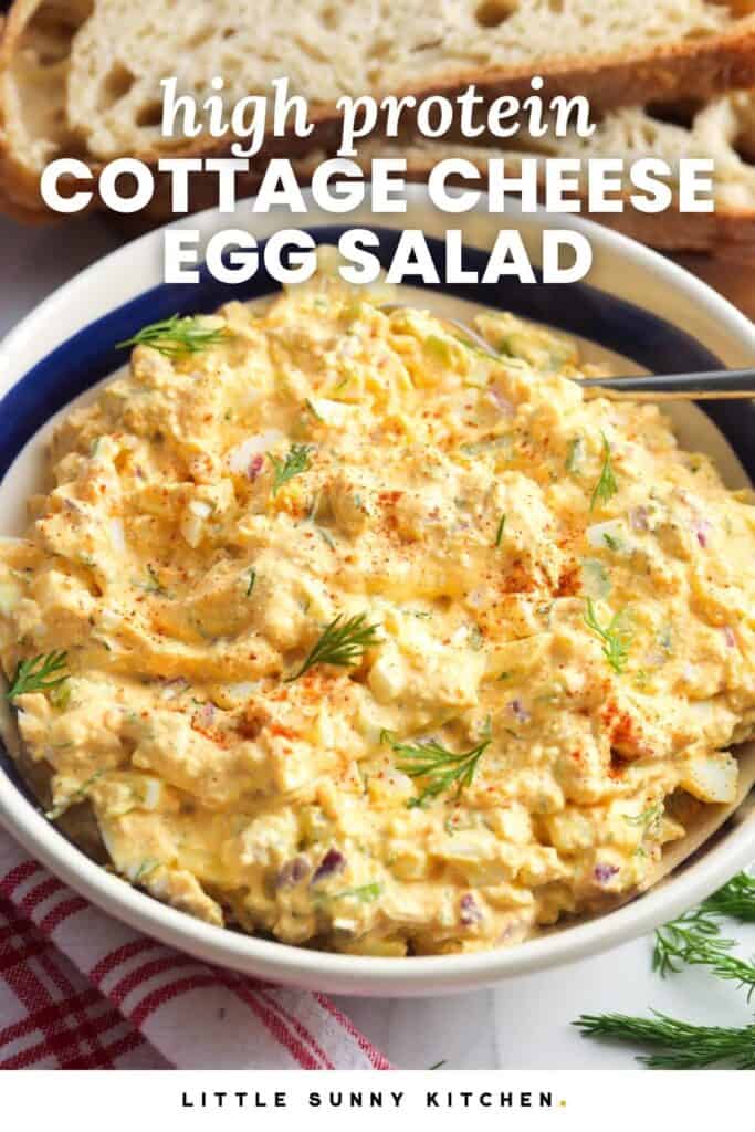 a large bowl of egg salad made with cottage cheese in front of slices of bread. Text overlay says "high protein cottage cheese egg salad"