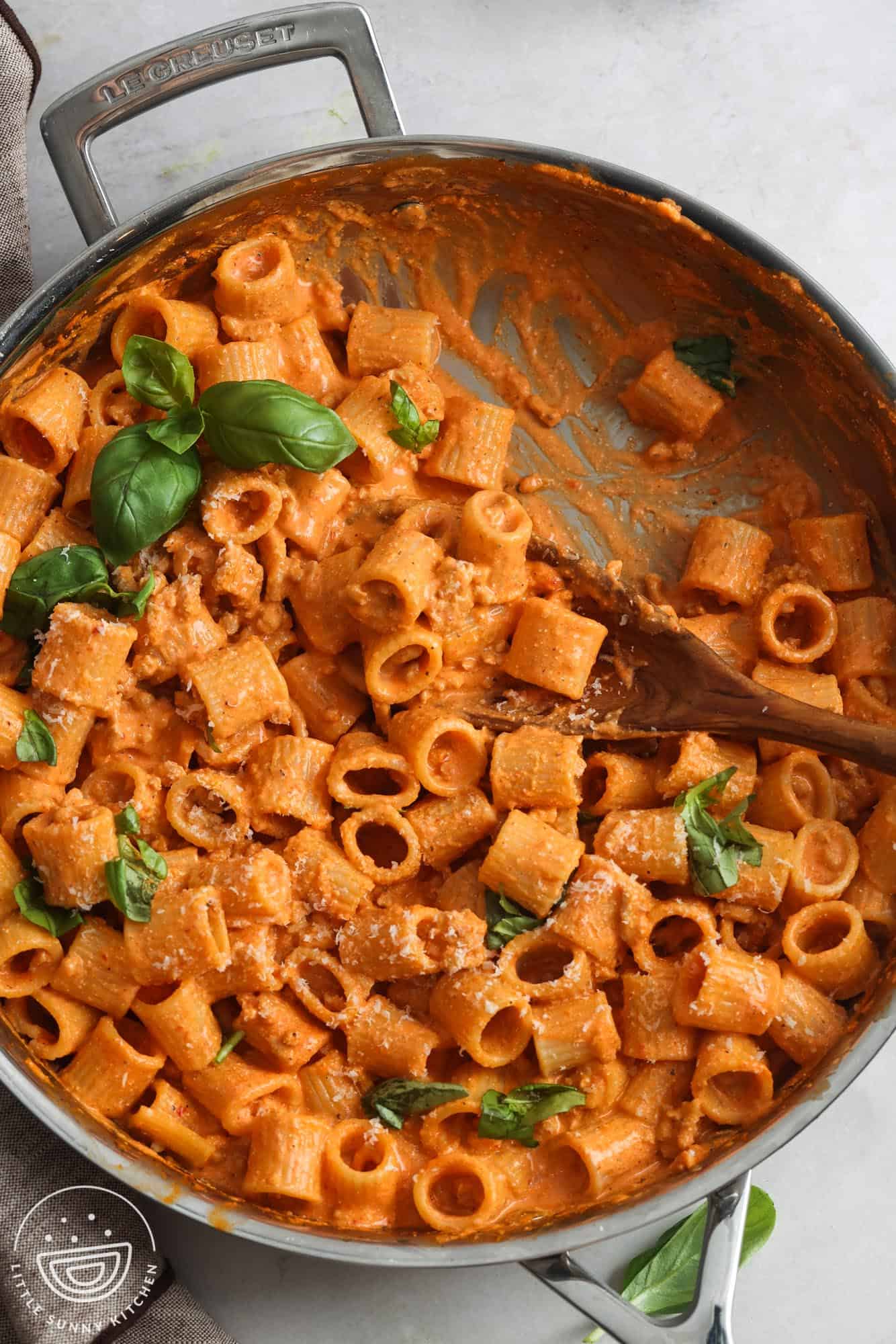 cottage cheese pasta sauce with roasted red bell pepper and chicken in a skillet, garnished with fresh basil leaves.