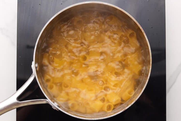 rigatoni boiling in a pot of water, viewed from overhead.