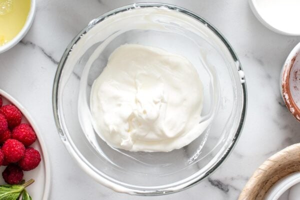 whipped cream in a glass mixing bowl.