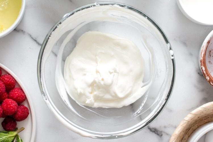 whipped cream in a glass mixing bowl.
