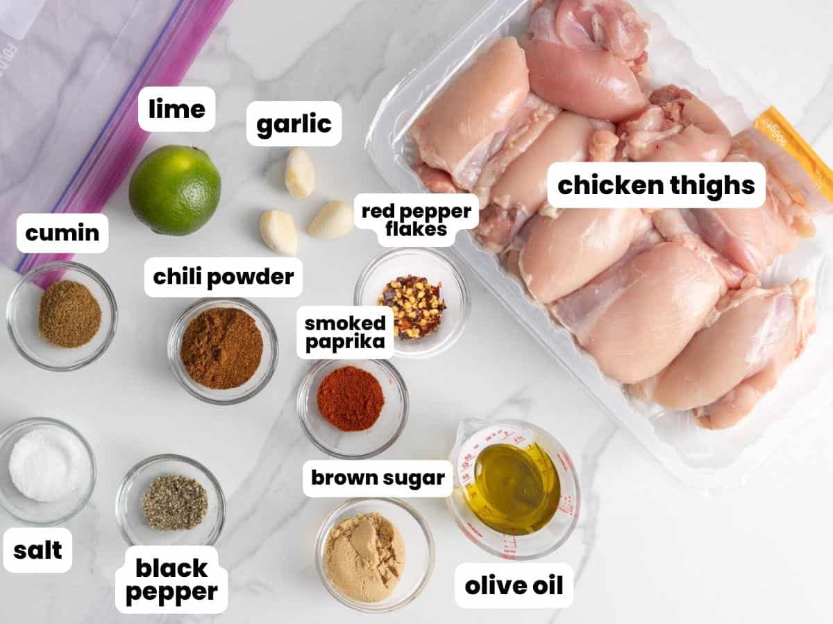A package of boneless chicken thighs next to the ingredients for a chili lime chicken marinade.