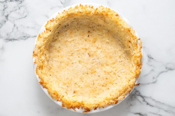 partially baked hash brown quiche crust with golden brown edges.