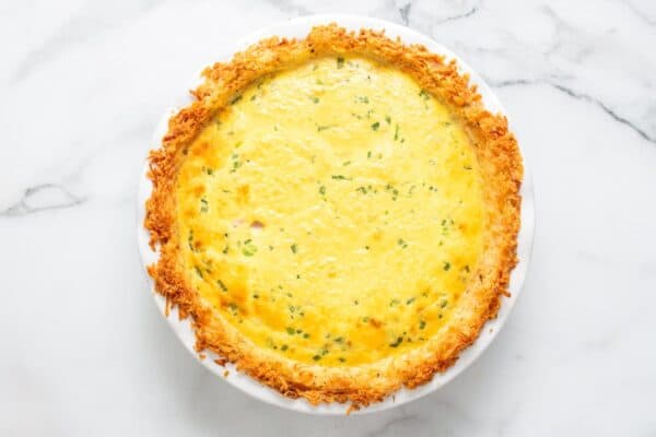 baked hash brown crust quiche on a marble counter, viewed from overhead.