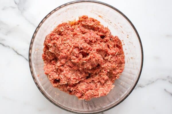meat mixture for mini meatloaf in a glass mixing bowl