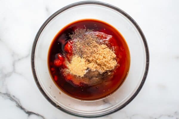 a small glass bowl with ketchup, sugar, and seasonings to make meatloaf glaze.