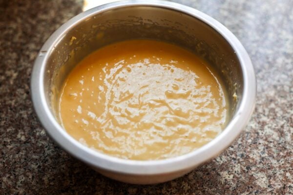 Thick yogurt pound cake batter in a metal bowl.