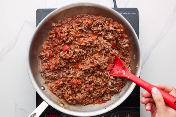 ground beef and tomato mixture for stuffed peppers in a stainless steel skillet.