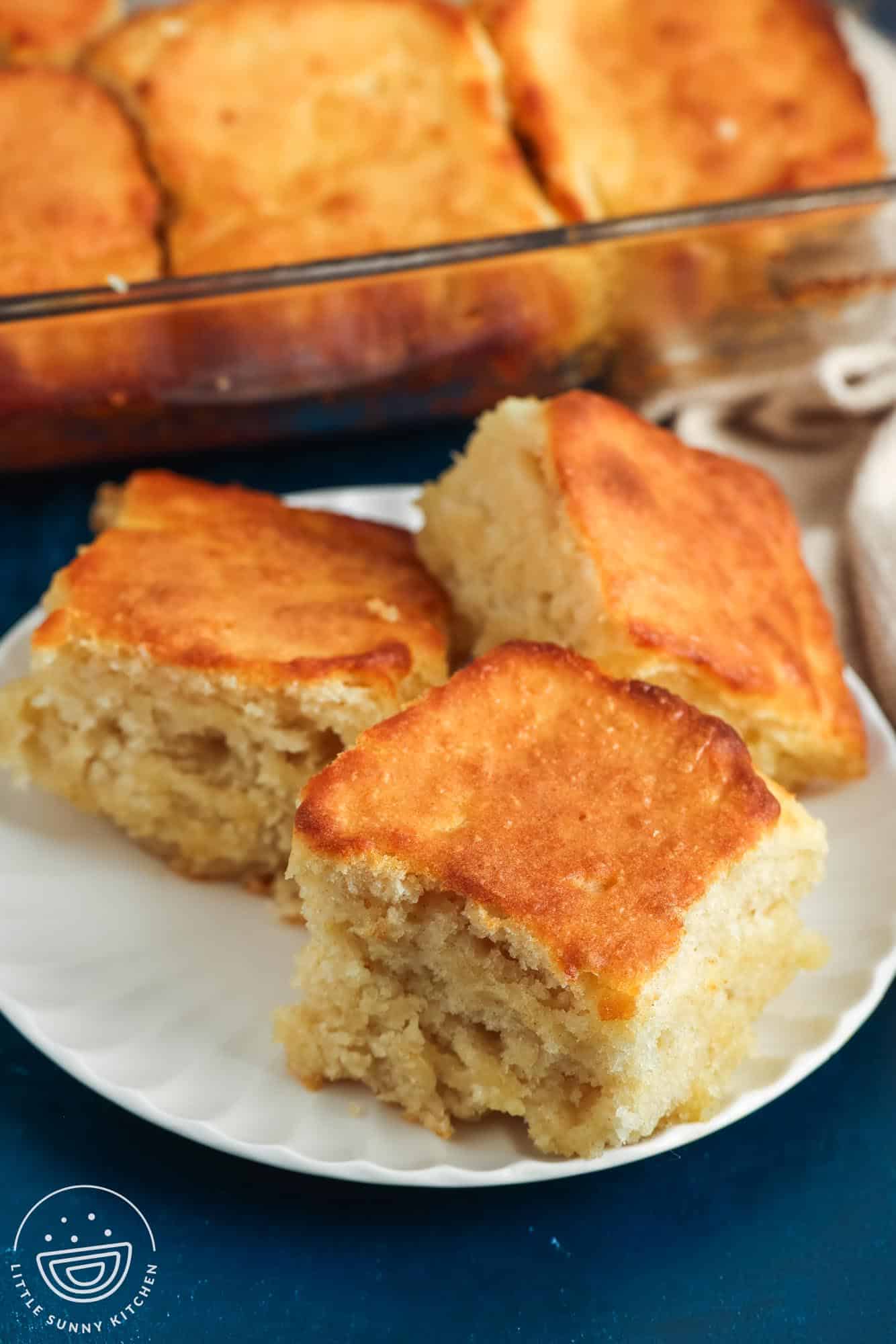 three square butter swim biscuits on a white plate.