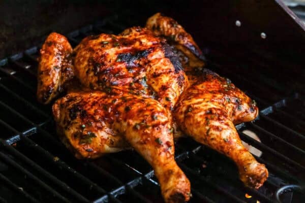 grilled spatchcocked chicken on a gas grill, basted with honey lime marinade.
