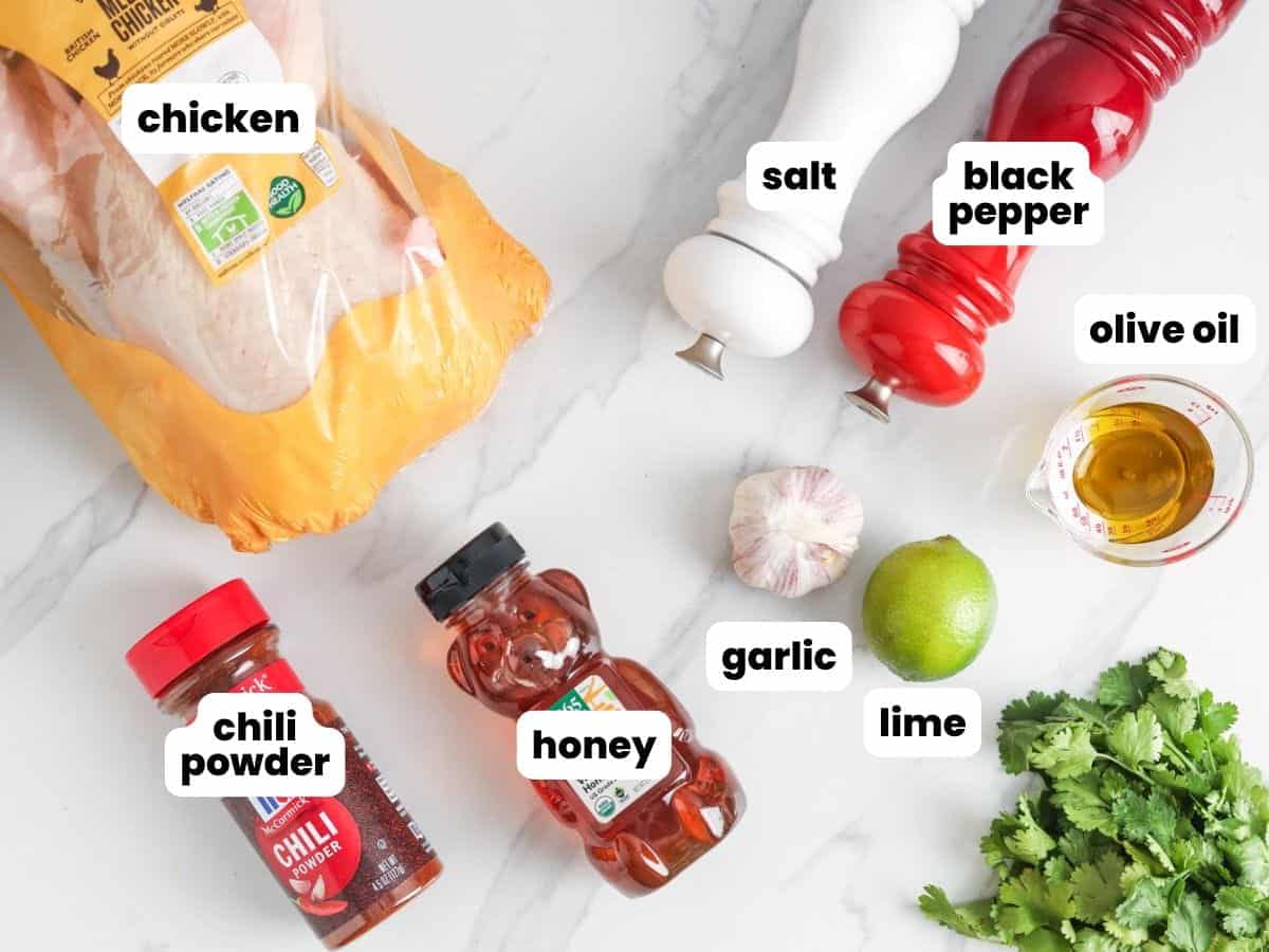 Ingredients for making cilantro lime marinated chicken on a marble counter.
