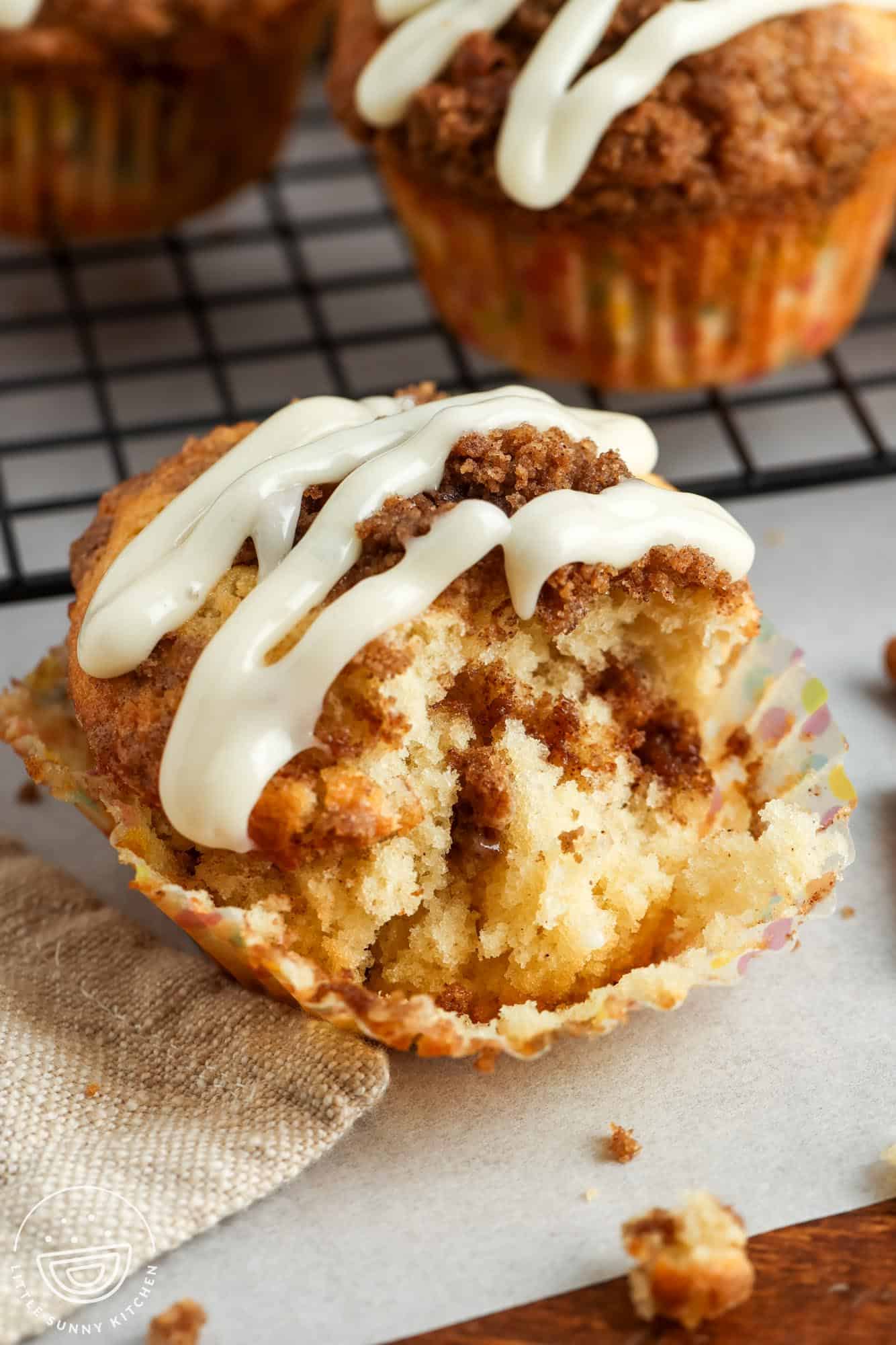 a cinnamon muffin removed from its wrapper. A bite has been taken to show the fluffy texture.