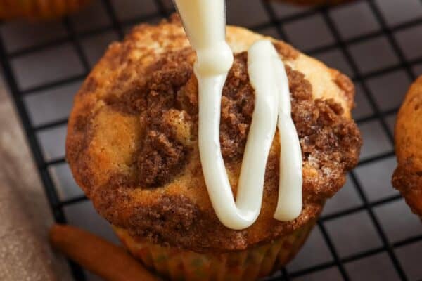 icing piped in lines over cooled cinnamon roll muffins