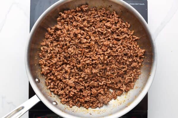 browned ground beef in a stainless steel skillet.