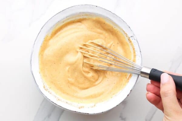 dressing for cowboy pasta salad whisked in a ceramic bowl.