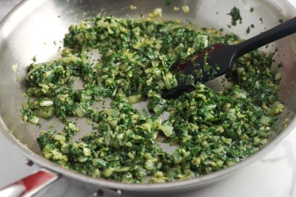 onion, cilantro, and garlic cooking in a skillet.