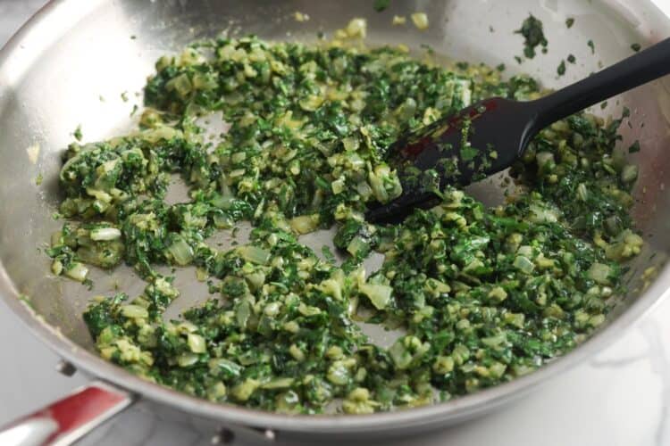 onion, cilantro, and garlic cooking in a skillet.