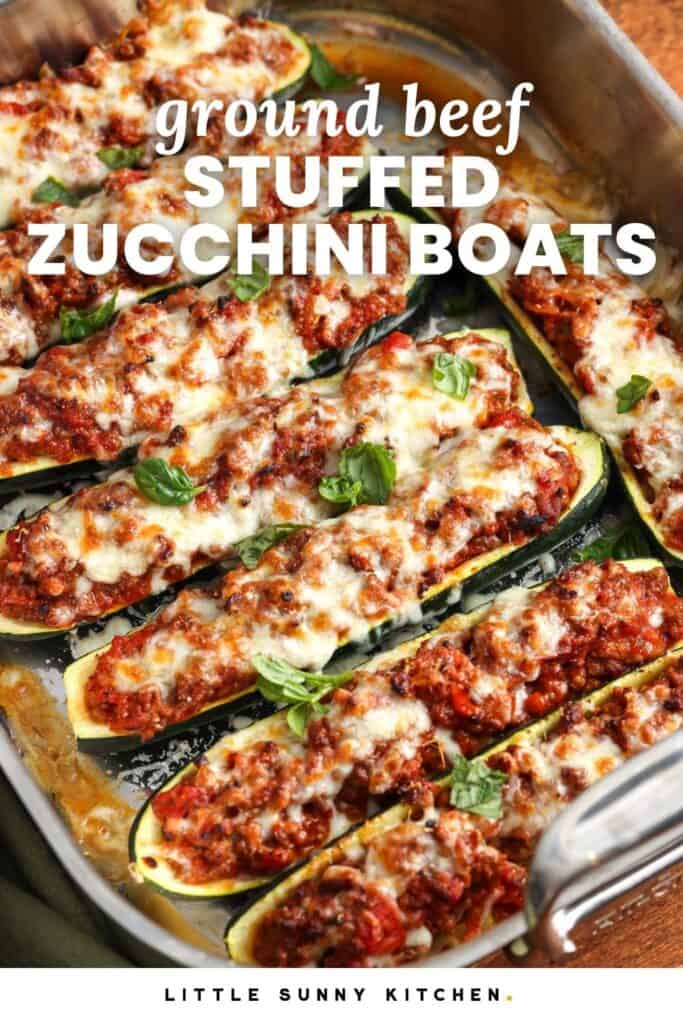 baked zucchini boats in a roasting pan. Text overlay says "ground beef stuffed zucchini boats"
