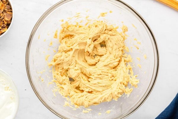 Cream cheese, peanut butter, and powdered sugar mixture whipped until smooth in a glass bowl.