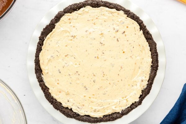 Butterfinger filling spread evenly over the Oreo crust.