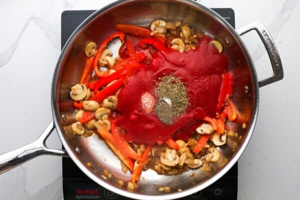 tomato sauce and seasonings added to sauteed vegetables to make the sauce for chicken pizzaiola.