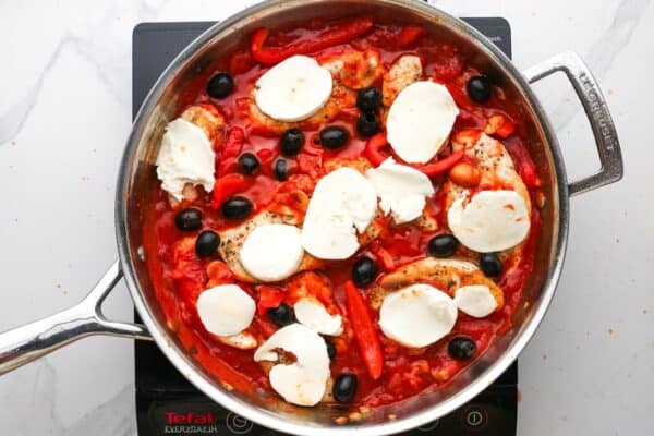 slices of fresh mozzarella and whole black olives added to a skillet of chicken pizzaiola.