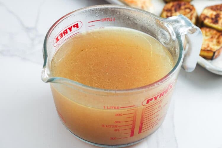 maqluba chicken broth strained into a glass 1 liter measuring cup.