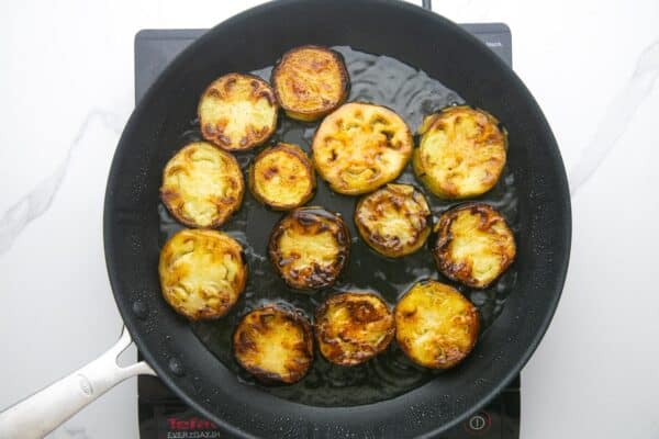 slices of eggplant fried in oil in a nonstick pan.