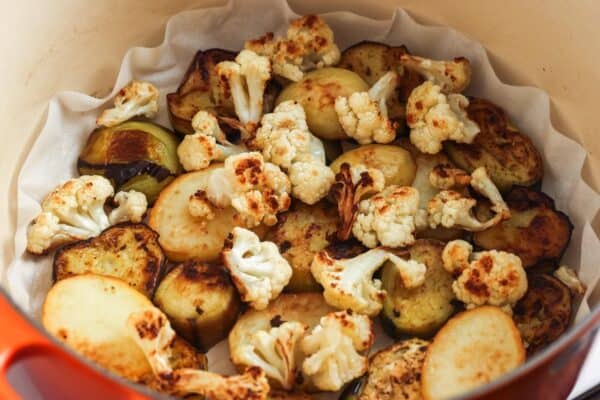 fried cauliflower pieces, potato slices, and eggplant slices draining on paper towels.