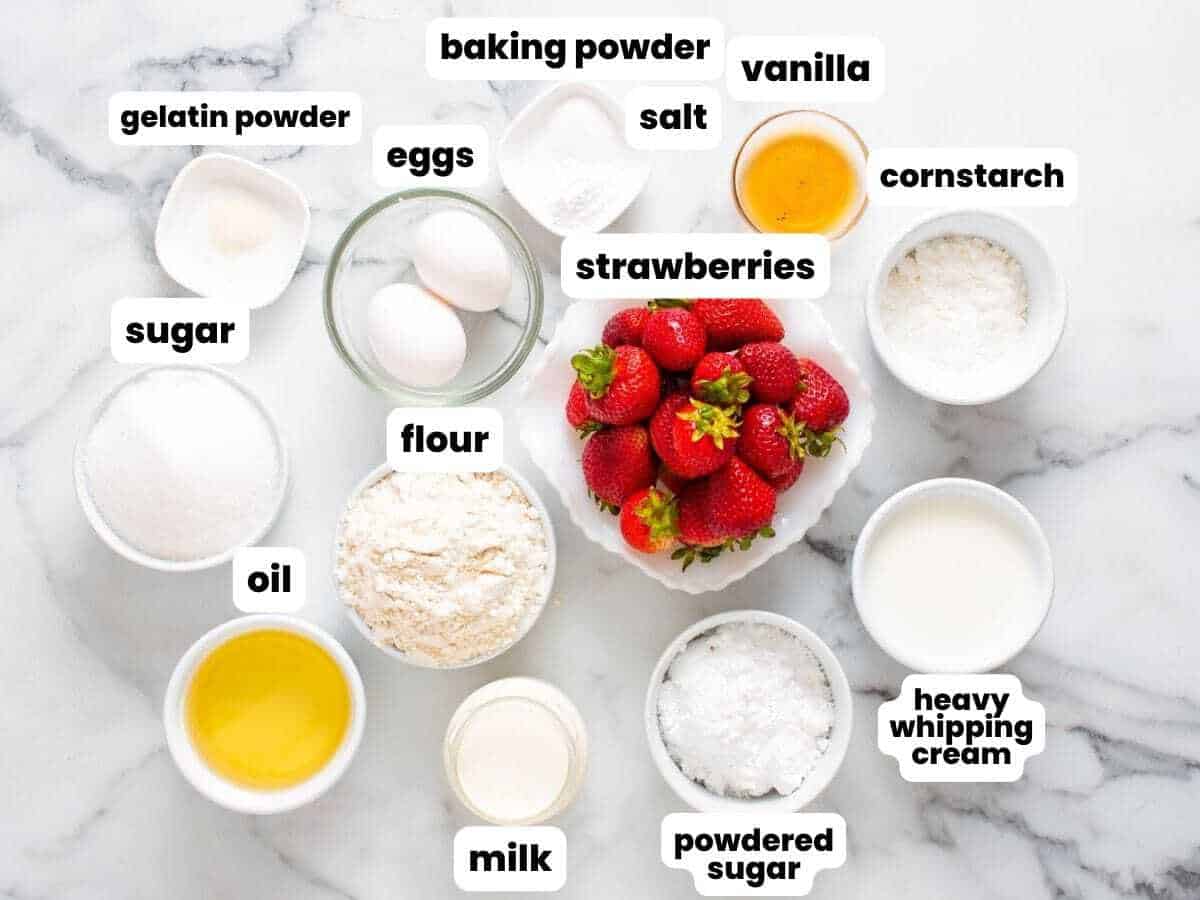 The ingredients for making strawberry shortcake cupcakes from scratch, including fresh berries and whipped cream.