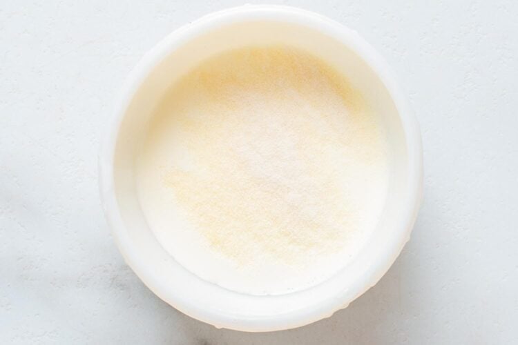 gelatin powder blooming in a small bowl of heavy cream.