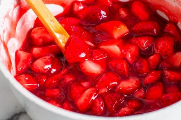 glossy strawberry compote in a white bowl.