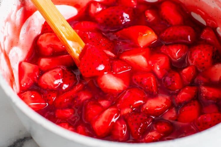 glossy strawberry compote in a white bowl.