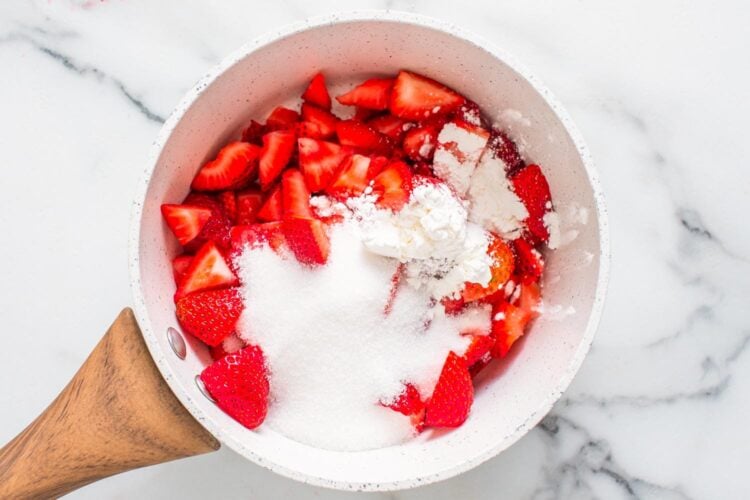 strawberries in a small pot with granulated sugar and cornstarch.