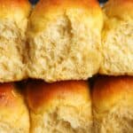 two rows of sweet potato dinner rolls stacked on top of each other. The rolls viewed from the side are fluffy and airy.