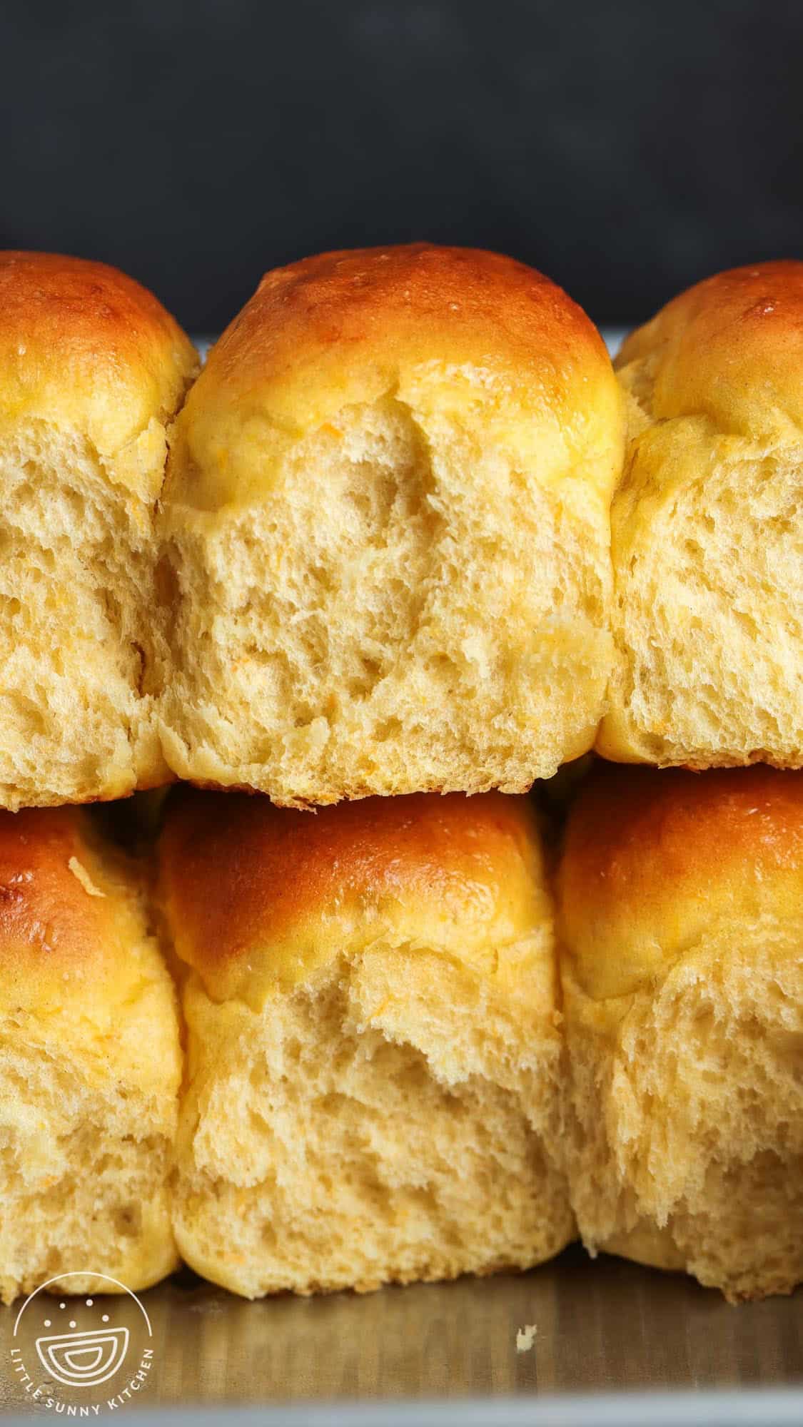 two rows of sweet potato dinner rolls stacked on top of each other. The rolls viewed from the side are fluffy and airy.