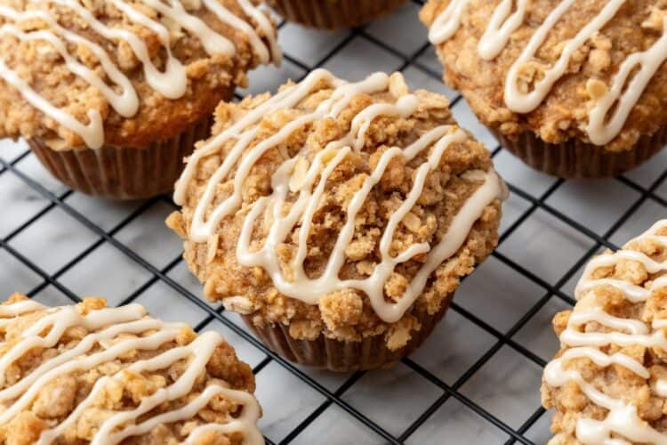 apple oat muffins on a wire rack, drizzled with maple icing.
