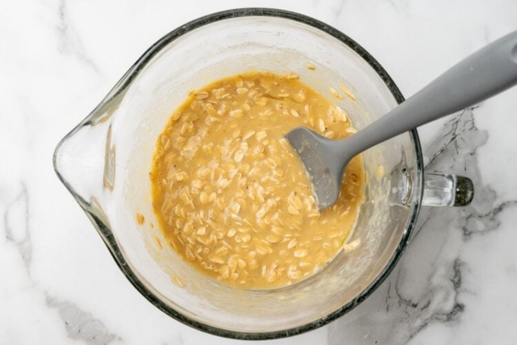 oat mixture for muffins after sitting for 5 minutes. the oats are softened and have absorbed some of the milk.