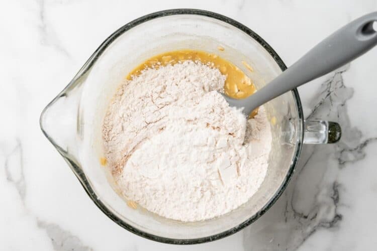 dry ingredients added to wet ingredients to make apple oat muffins.