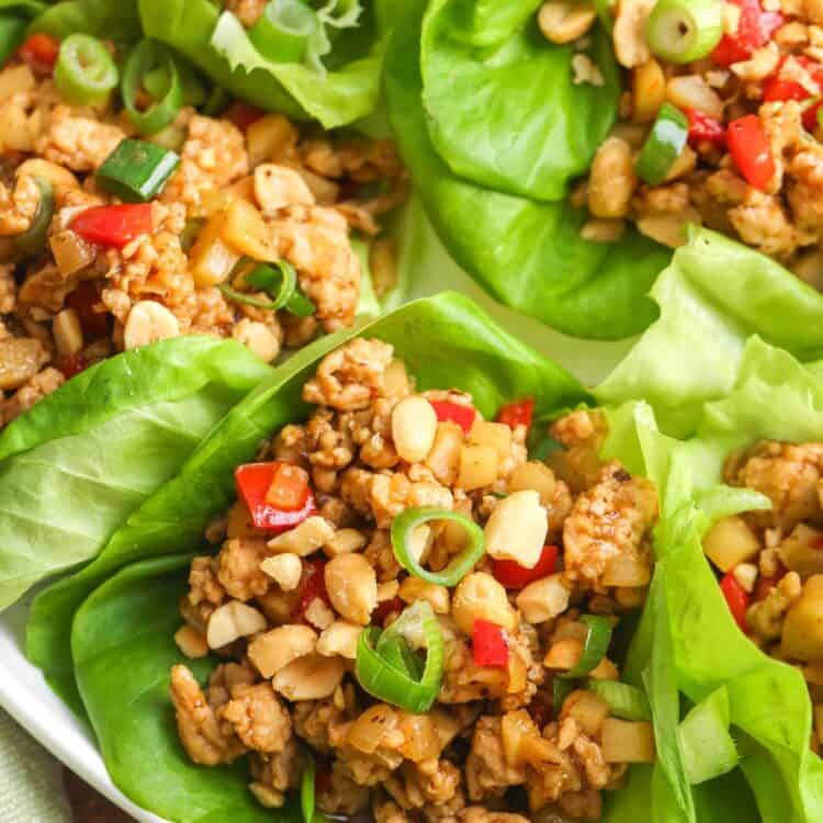 Asian chicken lettuce wraps, assembled on a white plate.