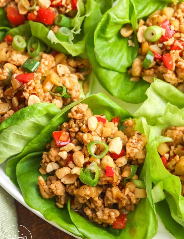 Asian chicken lettuce wraps, assembled on a white plate.