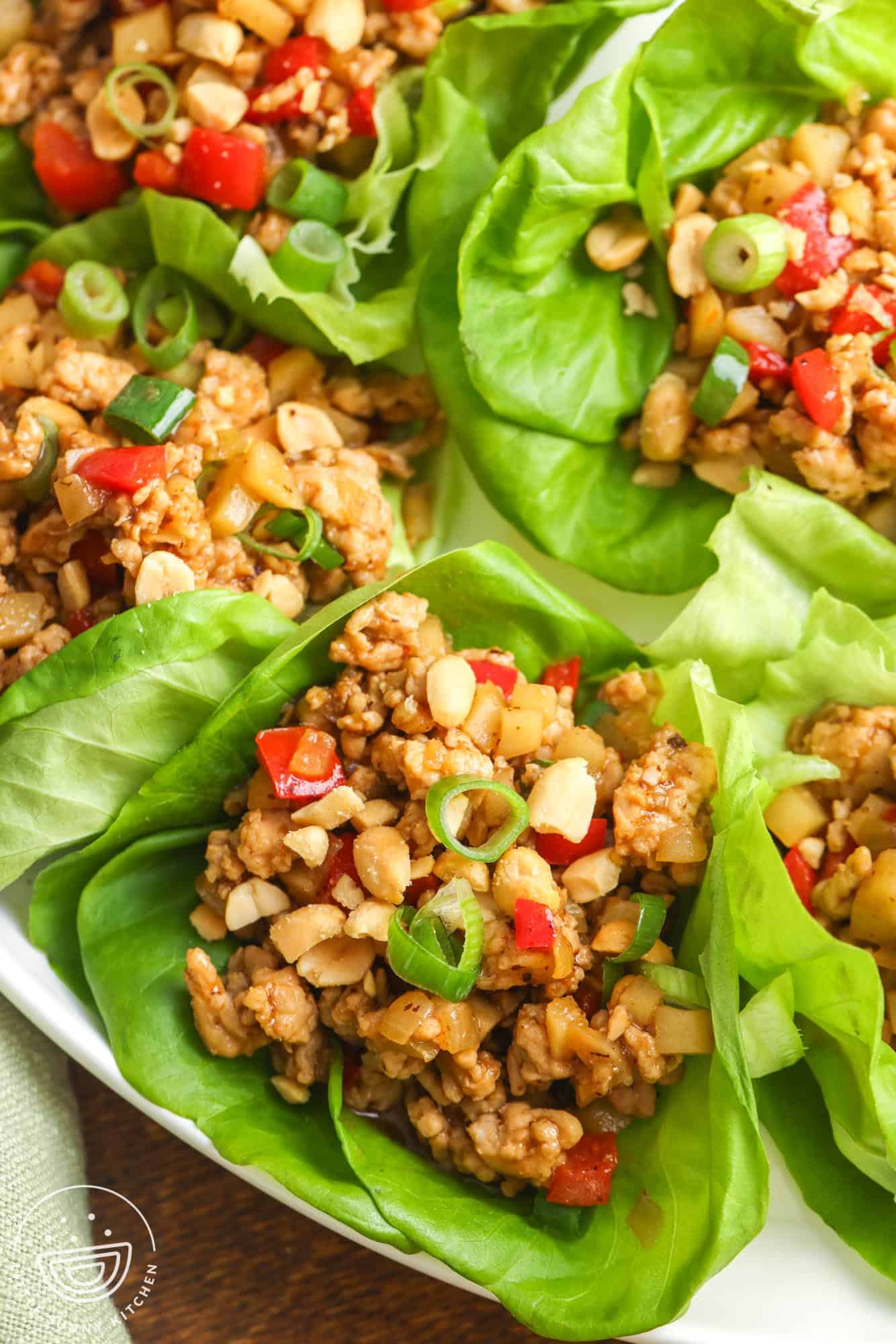 Asian chicken lettuce wraps, assembled on a white plate.