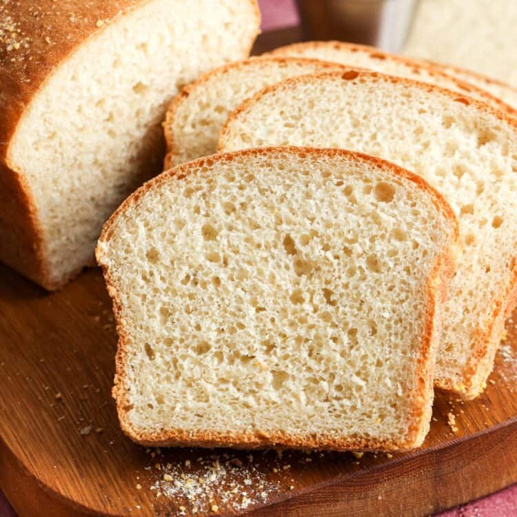 a loaf of English muffin bread, sliced to show the chewy crumb with nooks and crannies.