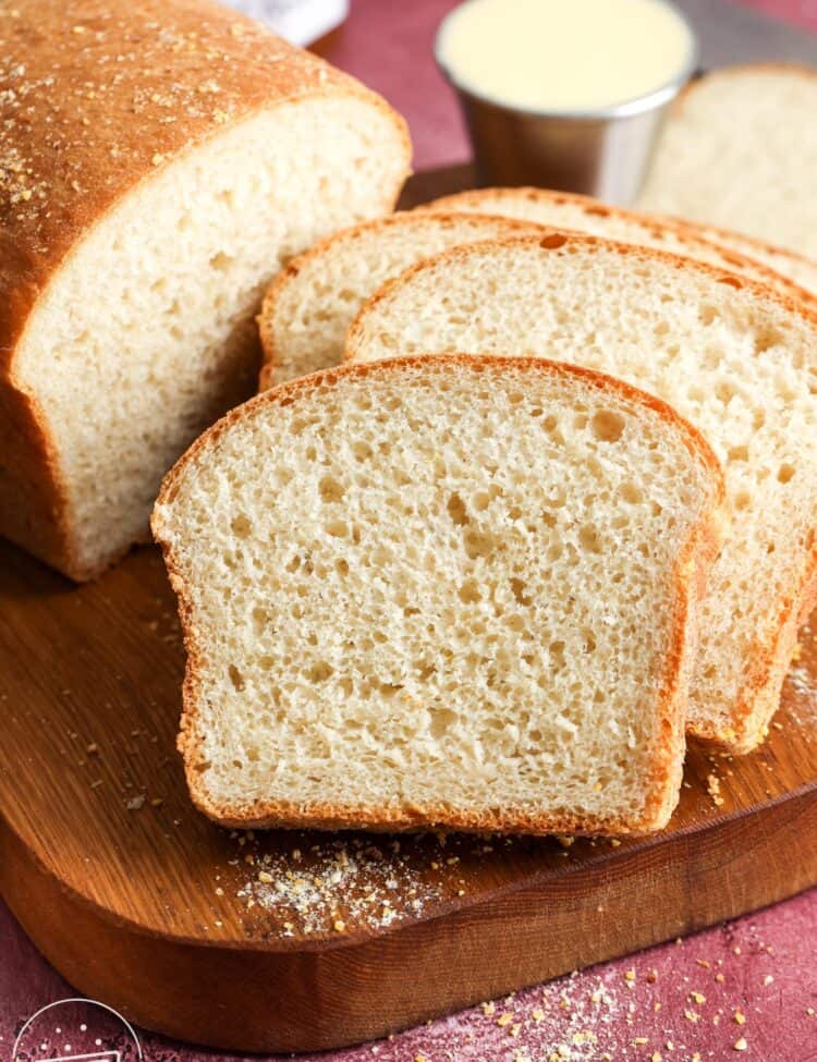 a loaf of English muffin bread, sliced to show the chewy crumb with nooks and crannies.