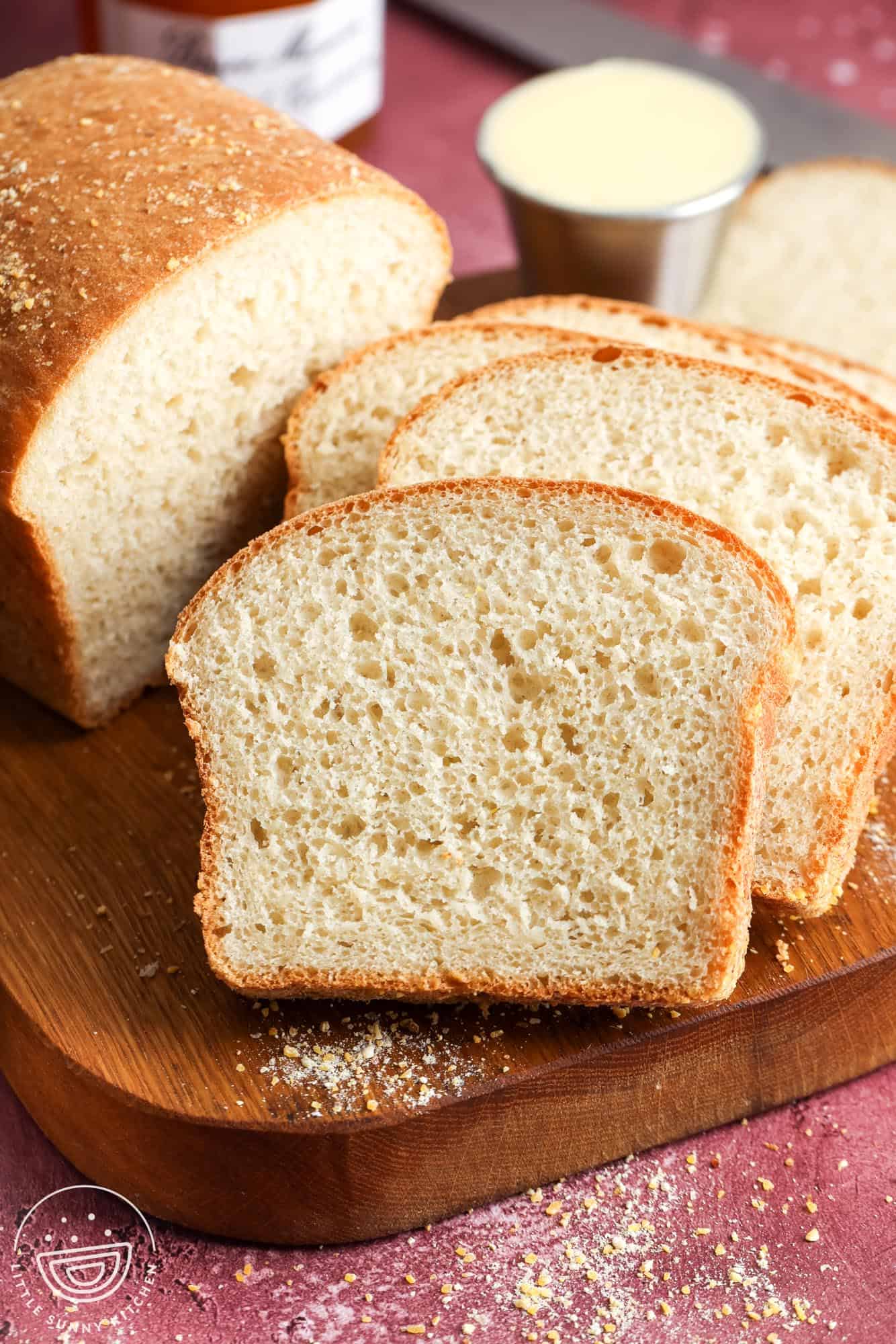 a loaf of English muffin bread, sliced to show the chewy crumb with nooks and crannies.