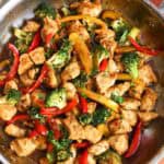 overhead view of a skillet holding hoisin chicken with broccoli and peppers.