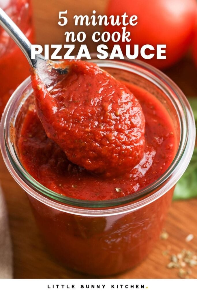 A spoonful of thick red pizza sauce being lifted from a glass jar with the text overlay “5 minute no cook pizza sauce.”