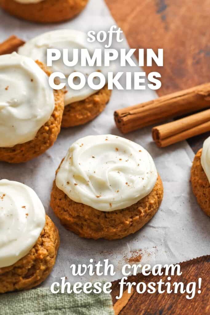 Soft pumpkin cookies topped with swirls of cream cheese frosting, sprinkled with cinnamon, and arranged on parchment paper with cinnamon sticks.